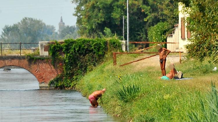 Fiumi e canali, le famiglie sfidano i divieti: in acqua anche i bambini